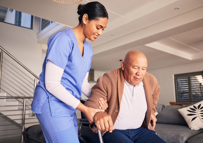 Home health aide helping patient with disability