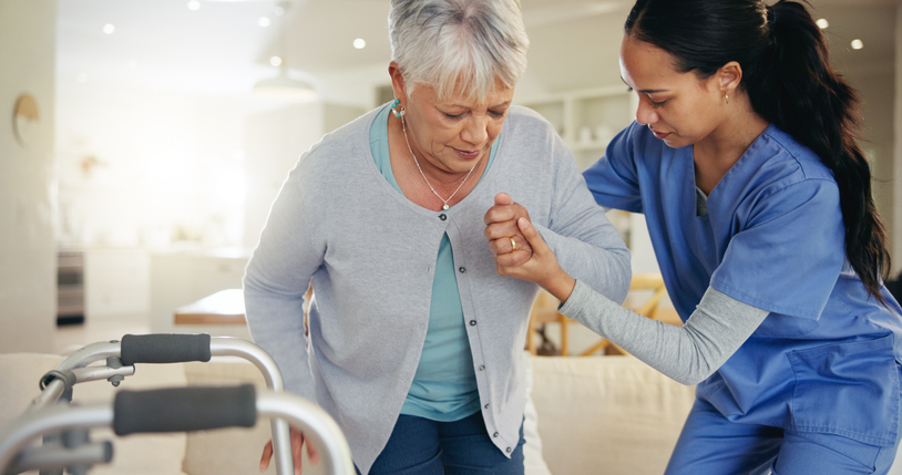 Senior woman, person with disability and nurse for help to couch, walking frame and handholding.